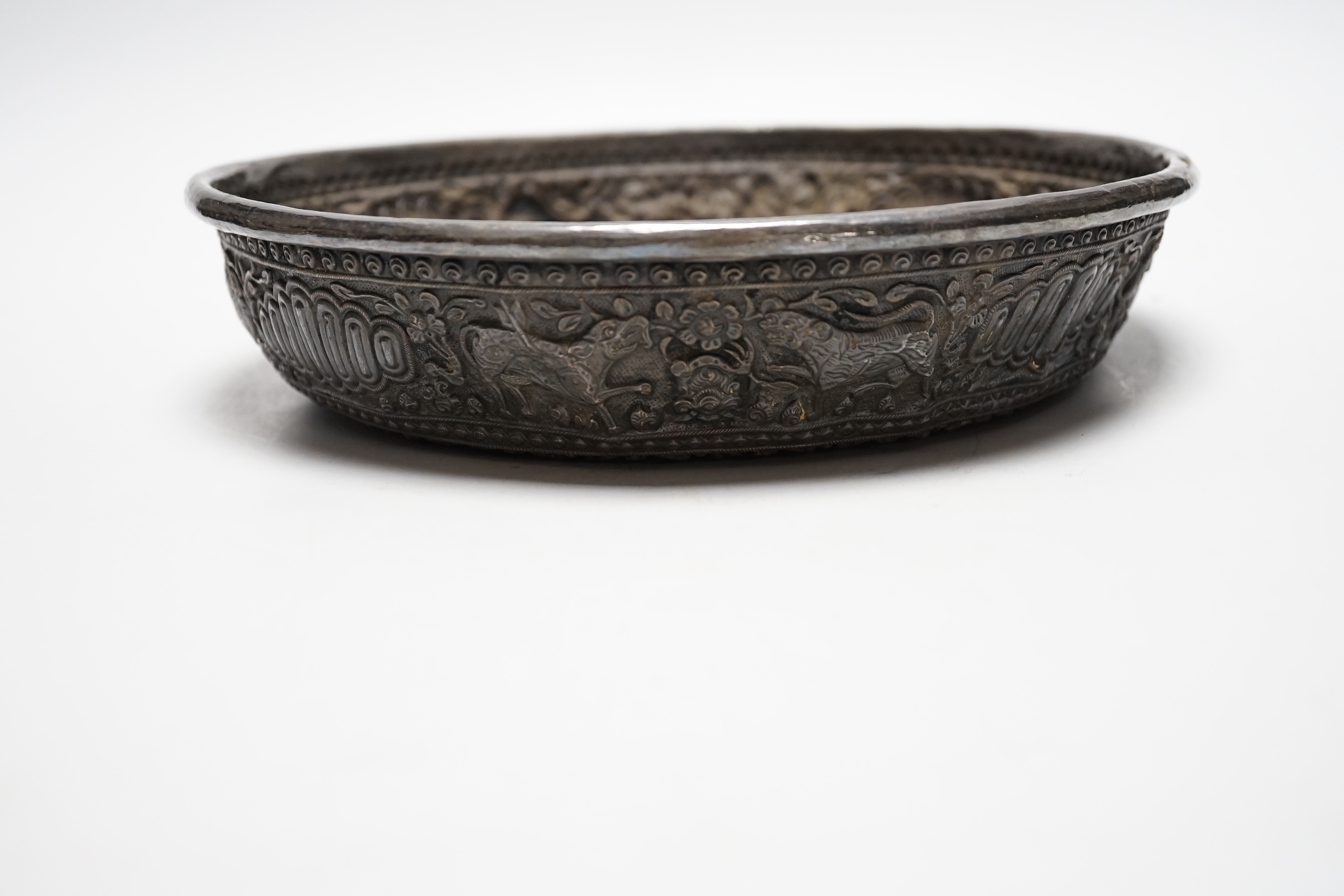 An Asian embossed white metal (tests as silver) shallow bowl, 25.2cm, 13.5oz.